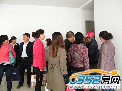 工作人员正在为业主介绍财富官邸准现房的交房标准