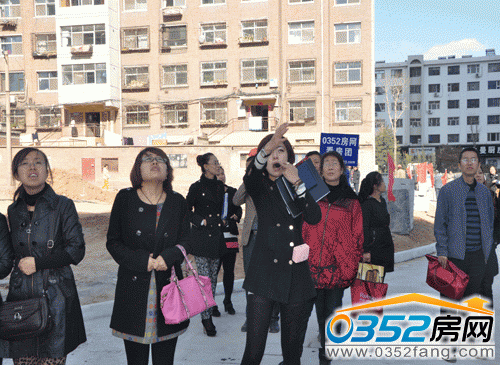 理想城置业顾问向顾客介绍小区景观