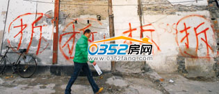 2010年12月16日,市民从上海市中心一栋待拆迁的楼房前走过。 \